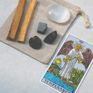 Top view of tarot card and healing stones on a canvas bag, ideal for spiritual and alternative healing themes.